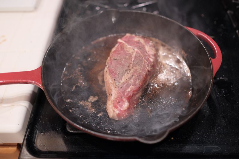 Sizzling steak fajitas on cast iron skillet at Chuys